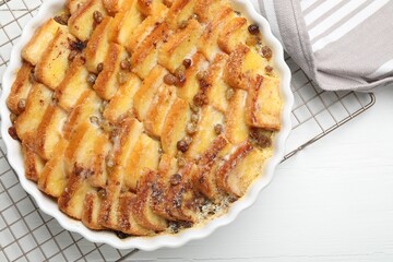 Delicious bread pudding with raisins on white table, top view