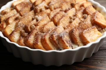 Delicious bread pudding with raisins and cinnamon on wooden table, closeup