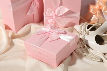 Beautiful wedding gifts, bridal shoes and pearl jewelry on silk fabric