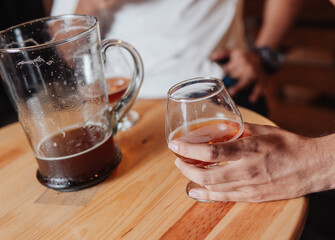 hand taking a glass of beer in a bar