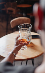 hand taking a glass of beer in a bar
