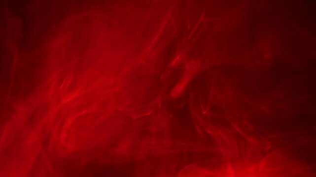 Wisps of red smoke and light swirling on black background