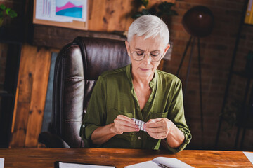 Photo of charming retired lady wear shirt drink pills suffer migraine workplace workstation loft...