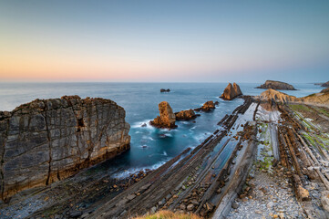 Dramatic view of Playa de la Arnia, Cantabria, Spain. Arnia Beach, Asturias at sunset. Amazing landscape, lines, abstract shapes beautiful colors.
