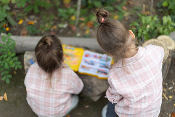 Back view of two childs drawing outdoor. Outdoor activities, kids imagination.