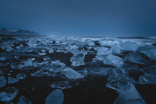Frozen Landscape with Ice Chunks on a Coastal Black Sand Beach in Iceland during Twilight
