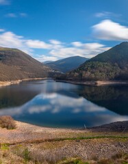 Un hermoso lago en medio de las monta&ntilde;as, con cielo azul y nubes