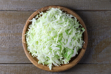 Fresh shredded cabbage on wooden table, top view