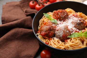 Delicious pasta with meatballs and cheese in bowl on table, closeup