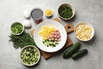 Different ingredients for okroshka soup on grey table, flat lay