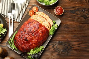Delicious turkey meatloaf with vegetables served on wooden table, flat lay. Space for text
