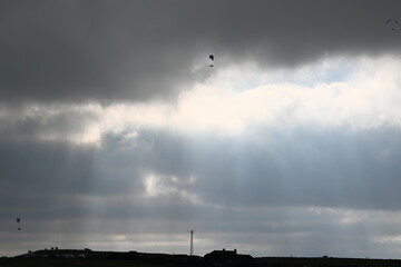 beechy head Eastbourne with a dramatic sky and paragliding in the background