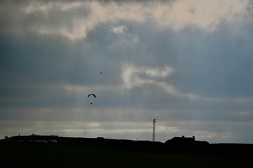 beechy head Eastbourne with an impressive dramatic sky and para-gliders in the background