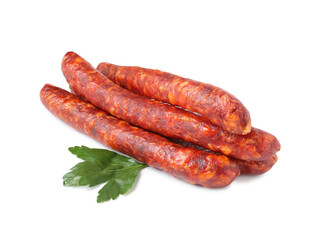 Many thin dry cured sausages with parsley isolated on white
