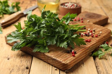 Fresh parsley and peppercorns on wooden table, closeup