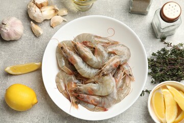 Fresh raw shrimps and spices on grey table, flat lay