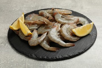 Fresh raw shrimps and lemon on grey table, closeup