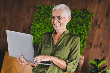 Photo of lovely nice lady boss dressed shirt eyewear hold netbook workplace workstation loft...