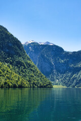 Mountains behind Konigssee with reflection in water on a clear sunny spring day in Bavaria, Germany.