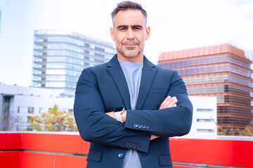 Confident Businessman Standing with Arms Crossed in Urban Setting