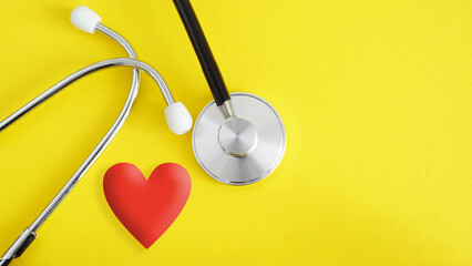 Heart and stethoscope on yellow background as symbol of healthcare and diagnosis medical cardiac...