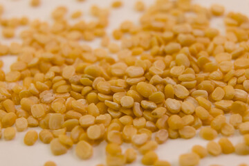 Dried yellow split peas scattered on a surface ready for cooking or use