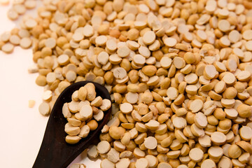 Dried chickpeas scattered with a wooden spoon on a kitchen surface