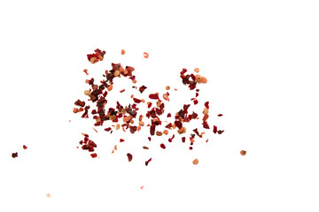 Dried chili flakes scattered on a plain background