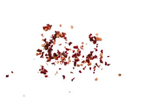 Dried chili flakes scattered on a plain background