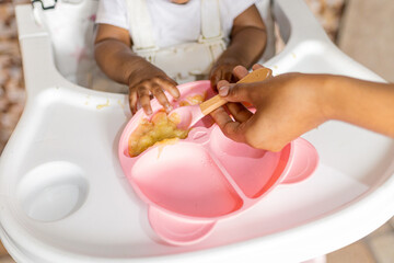 Spontaneous reaction of a child when introduced to food, eating for the first time. Rio de Janeiro, Brazil.