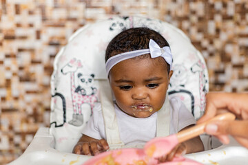Spontaneous reaction of a child when introduced to food, eating for the first time. Rio de Janeiro,...
