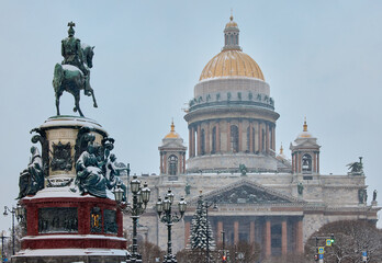 a snow-covered New Year's city decorated for the celebration of the new year, the golden dome of St. Isaac's Cathedral, walking tourists