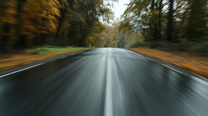Rainy autumn road view with motion blur in a forest, nature journey concept