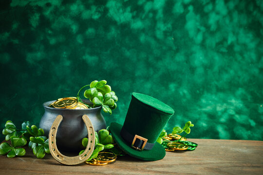 St. Patrick's Day Symbols. A festive setup with a pot of gold, leprechaun hat, horseshoe, and shamrocks