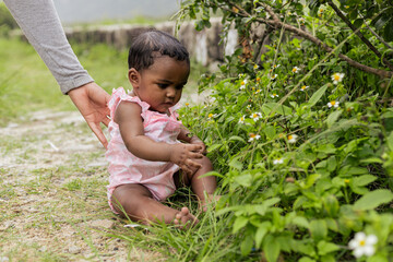 Happy baby girl on her first time playing in nature. Rio de Janeiro, Brazil.