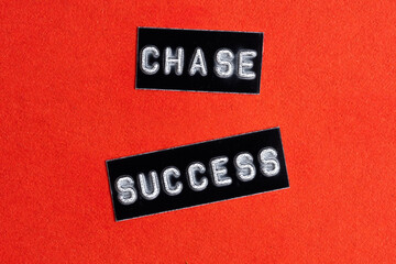 Closeup words CHASE SUCCESS on red background.