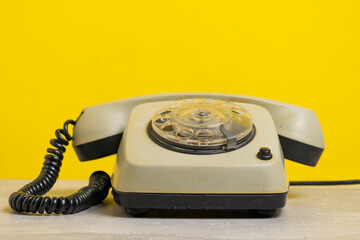 Old telephone on yellow background with copy space for your text or image.