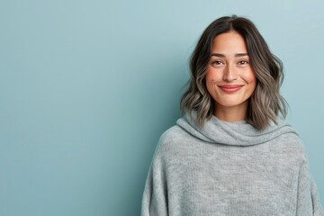 Fototapeta premium Light brown wavy hairstyle, shoulder-length haircut, natural and elegant hair design, soft waves with glossy texture, modern beauty portrait, casual and feminine style, isolated on blue background