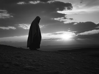 A solitary figure in a traditional pilgrim garb silhouetted against the rising sun, reflecting on their journey through the vast desert landscape.