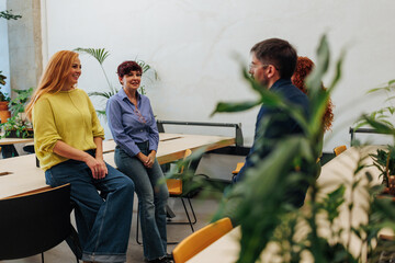 Coworkers exchanging ideas in modern office with plants