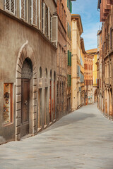 Obraz premium Old street in the historical center of Siena, the UNESCO World Heritage Centre unchanged for 13-14 centuries, with its medieval streets looked like in the early Middle Ages. Italy, 2019 