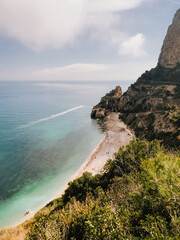 Motorboat sailing in sea near beach with its characteristic rock formations and crystalline waters popular tourist destination beach scene showcasing rocky cliffs and clear waters. vertical, film look