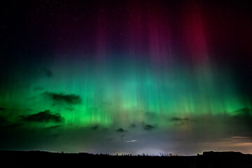 Colorful aurora borealis, beautiful beams of northern lights in the night sky against the background of stars.