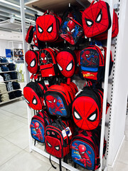 Naklejka premium Kyiv, Ukraine - February 05, 2025: Several colorful backpacks featuring Spider Man iconic superhero design displayed in a retail store