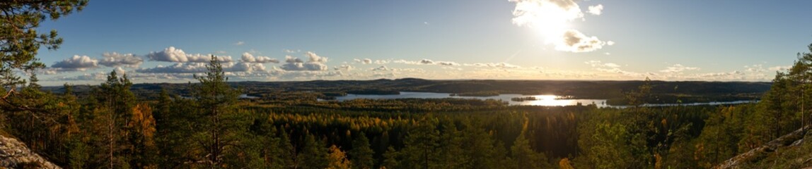 Expansive Sunset Panorama Over Nordic Forest and Lakes with Rolling Hills and Dramatic Cloudscape