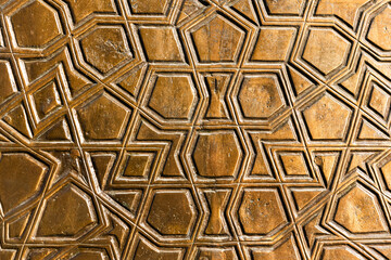 Ancient wall decoration with gold colored Arabic pattern