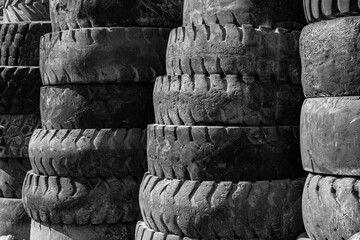 Landfill with stacked in row old tires and tyres  of various types and sizes for recycling.