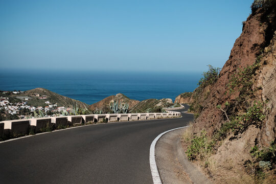 Scenic coastal road winding along a cliffside, overlooking a tranquil ocean.  Perfect for travel, adventure, and vacation themes. High-resolution image with vibrant colors.