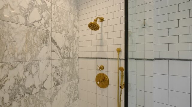 Modern shower area with combination of marble and subway tile walls. Left side of shower features large marble tiles with gray pattern while right side has white tiles 