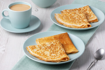 Delicious crepes served with a warm cup of coffee on a light wooden table in a cozy setting
